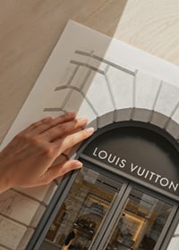 Store entrance with Louis Vuitton sign in stone facade, brown tones-9