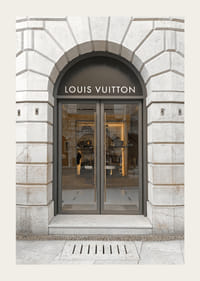 Store entrance with Louis Vuitton sign in stone facade, brown tones-3