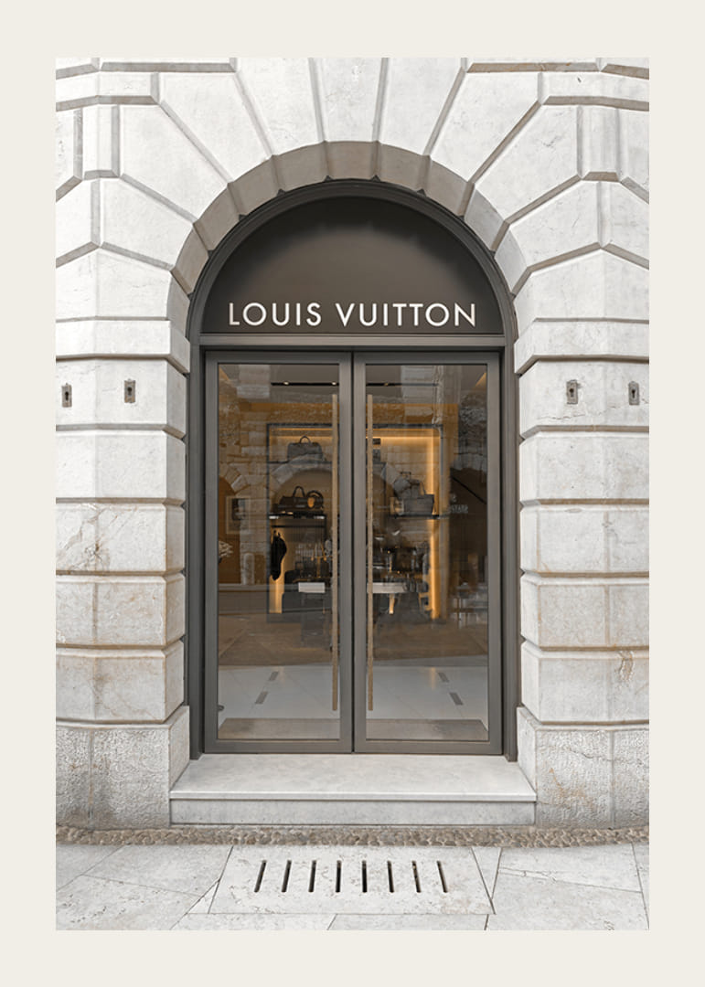 Store entrance with Louis Vuitton sign in stone facade, brown tones-12