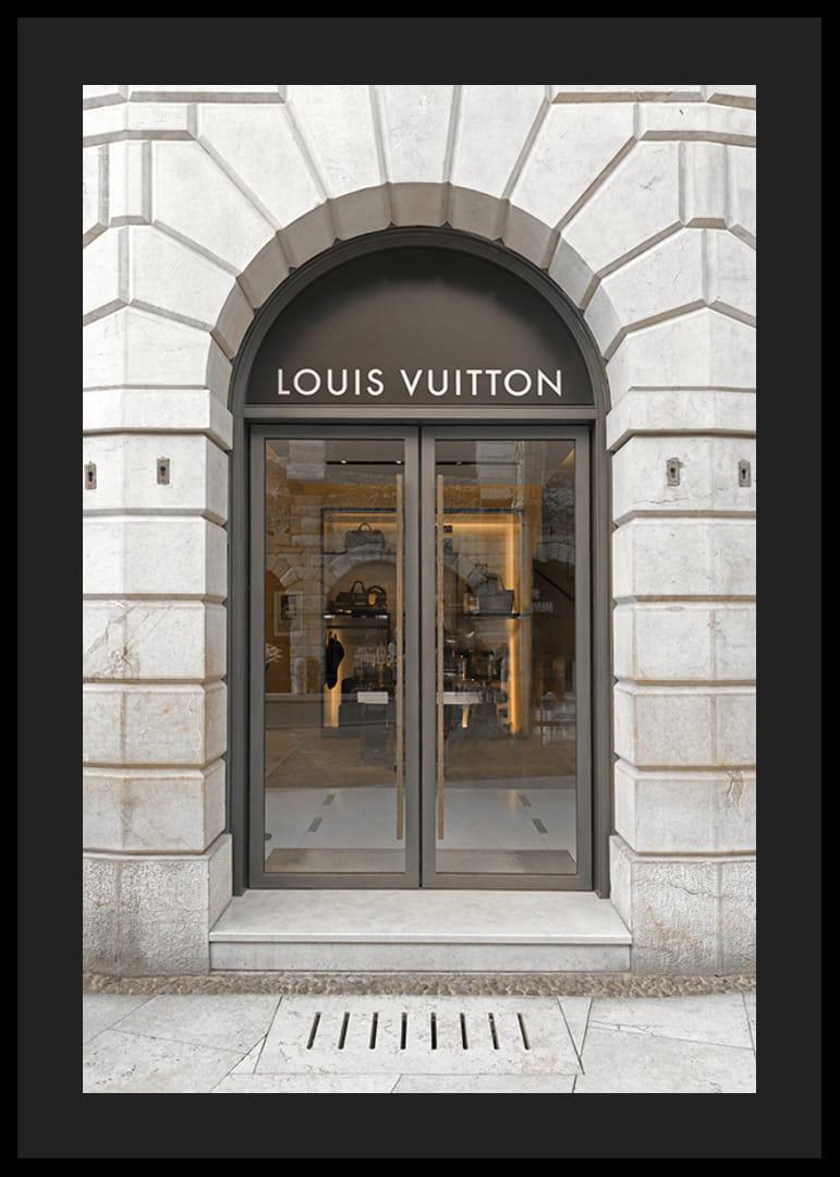 Store entrance with Louis Vuitton sign in stone facade, brown tones-12