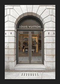 Store entrance with Louis Vuitton sign in stone facade, brown tones-5