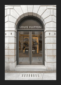 Store entrance with Louis Vuitton sign in stone facade, brown tones-5