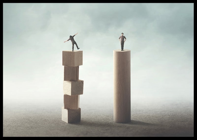 Two people balancing on wooden pillars against gray background-12