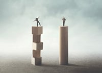 Two people balancing on wooden pillars against gray background-7