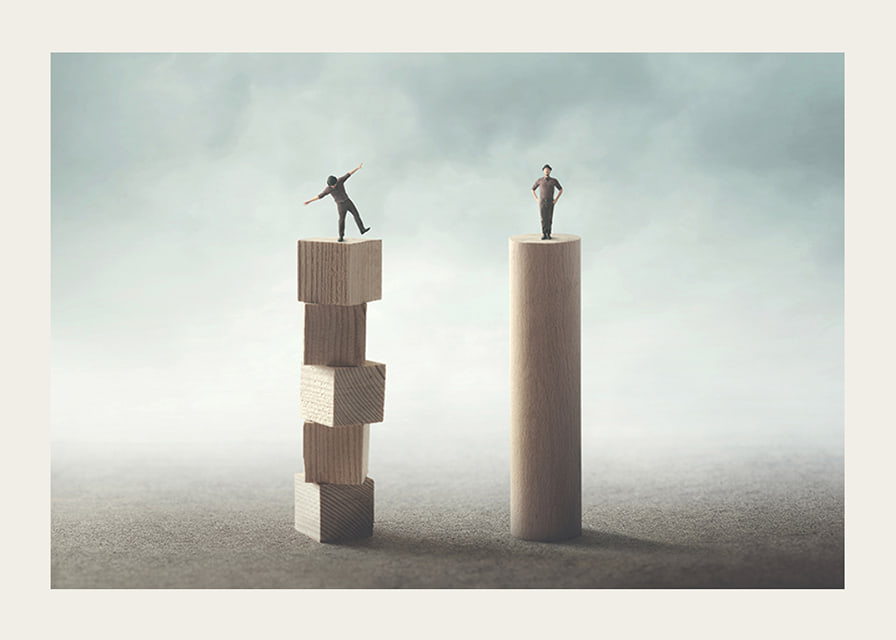 Two people balancing on wooden pillars against gray background-12
