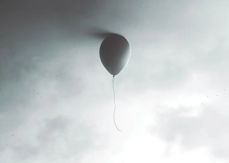 Surreal balloon against light gray sky with clouds-12