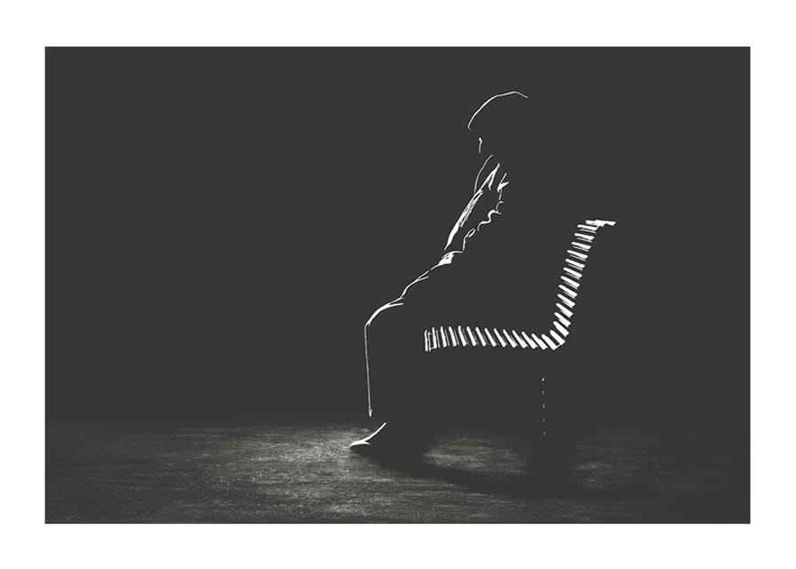 Iliustruotas vyro, sėdinčio ant suoliuko, siluetas tamsiais tonais-12