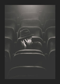 Illustrated man with hat hiding his face in dark cinema hall-1