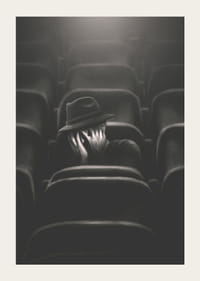 Illustrerad man med hatt gömmer ansiktet i mörk biosalong-5