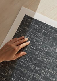 Muž v klobúku stojaci pred veľkou tabuľou s matematickými vzorcami-9