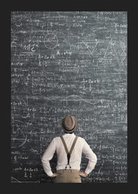 Man i hatt står framför stor griffeltavla med matematiska formler-5