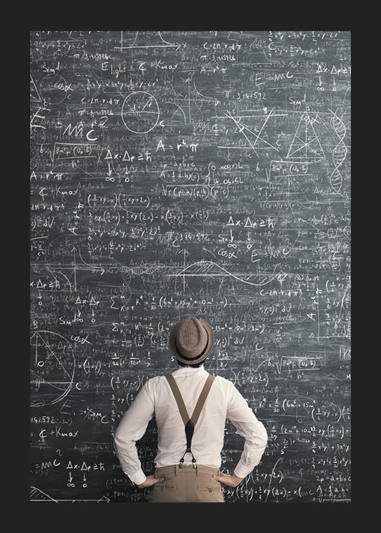 Man i hatt står framför stor griffeltavla med matematiska formler-12