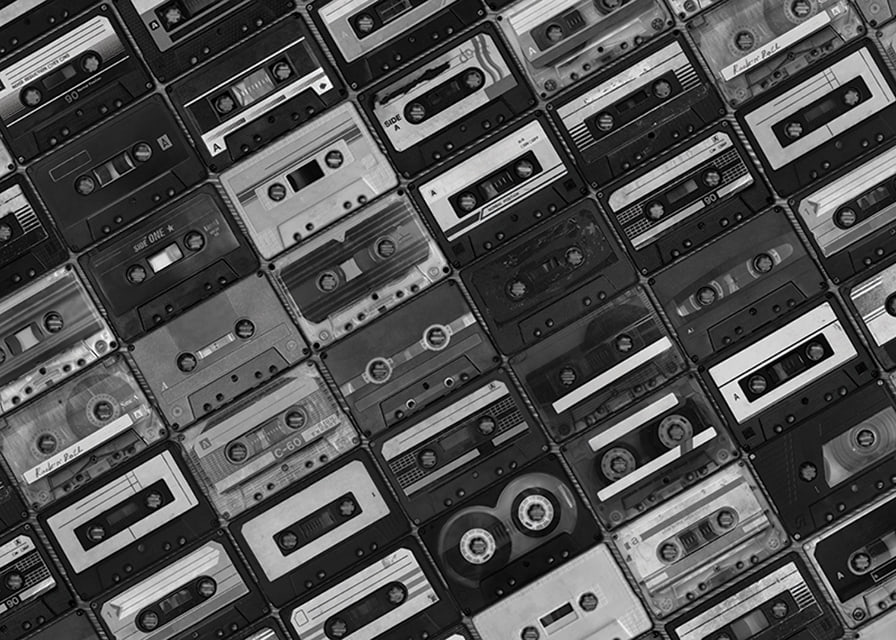 Black and white photograph of several cassette tapes in a checkerboard pattern-12