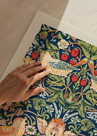 Trastar plockar jordgubbar bland blad och blommor-3