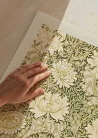 Tätt och stiliserat mönster med stora krysantemumblommor, slingrande blad och tunna grenar i mjuka gröna och beige toner-3