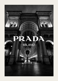 Black and white night image of illuminated arcade in Milan with Prada text-5