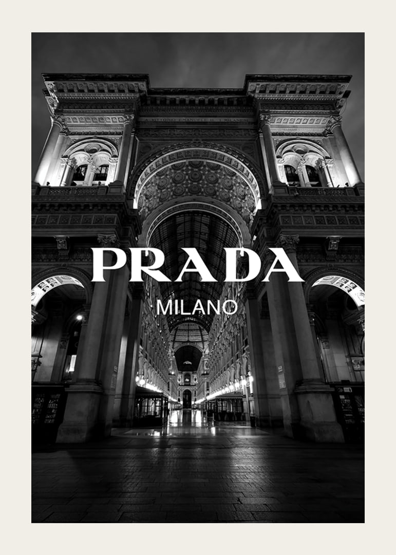 Black and white night image of illuminated arcade in Milan with Prada text-12