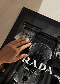 Black and white night image of illuminated arcade in Milan with Prada text-9
