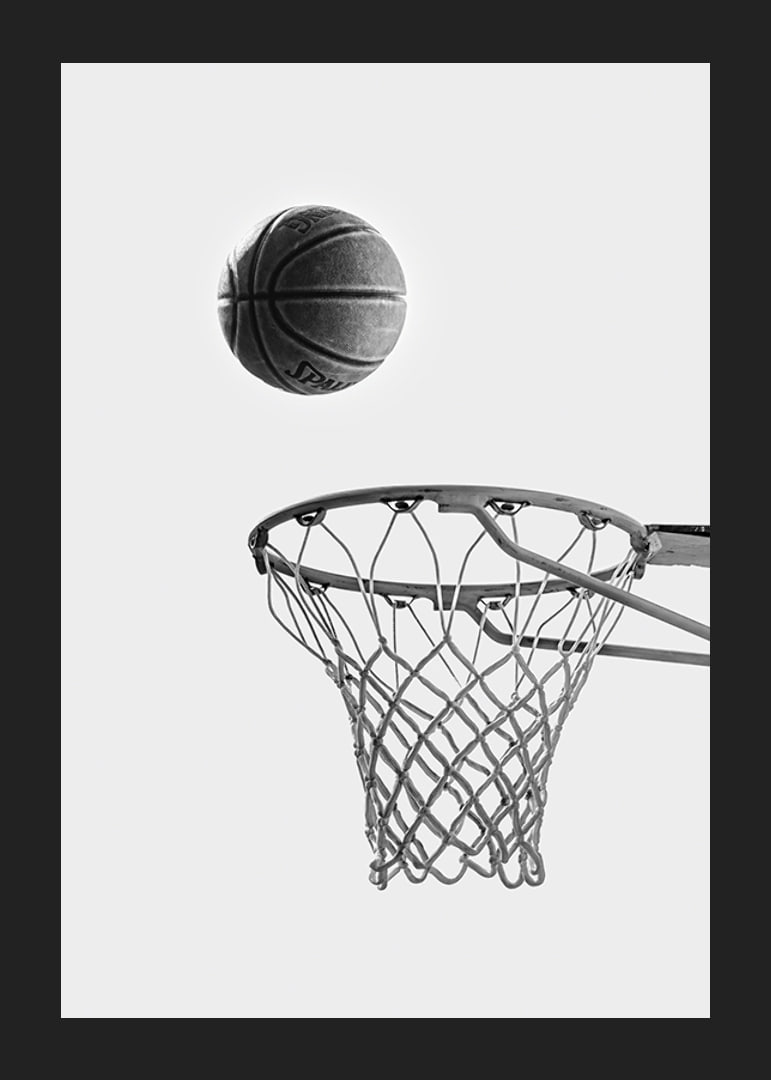 Black and white photo of basketball above basket against light background-12