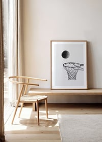 Black and white photo of basketball above basket against light background-8