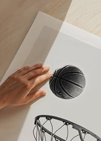 Black and white photo of basketball above basket against light background-9