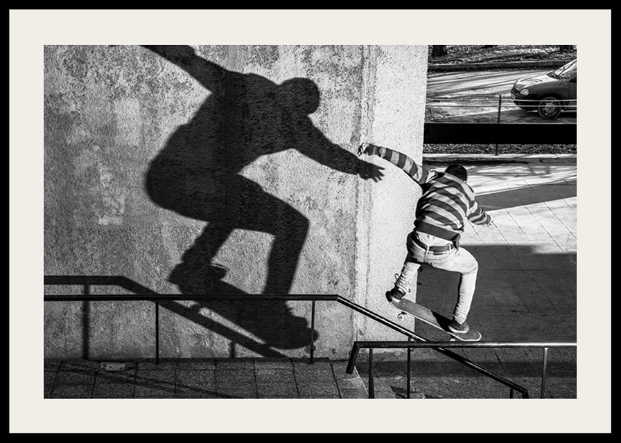 Foto em preto e branco de skatista escalando corrimão ao ar livre-12