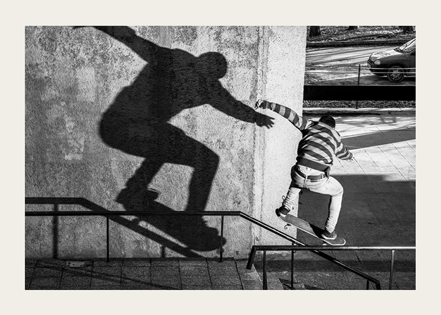 Foto em preto e branco de skatista escalando corrimão ao ar livre-12