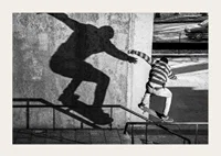Black and white photo of skateboarder climbing railing outdoors-3