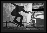 Black and white photo of skateboarder climbing railing outdoors-4