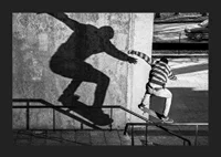 Black and white photo of skateboarder climbing railing outdoors-5