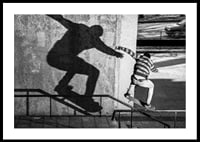 Foto em preto e branco de skatista escalando corrimão ao ar livre-0