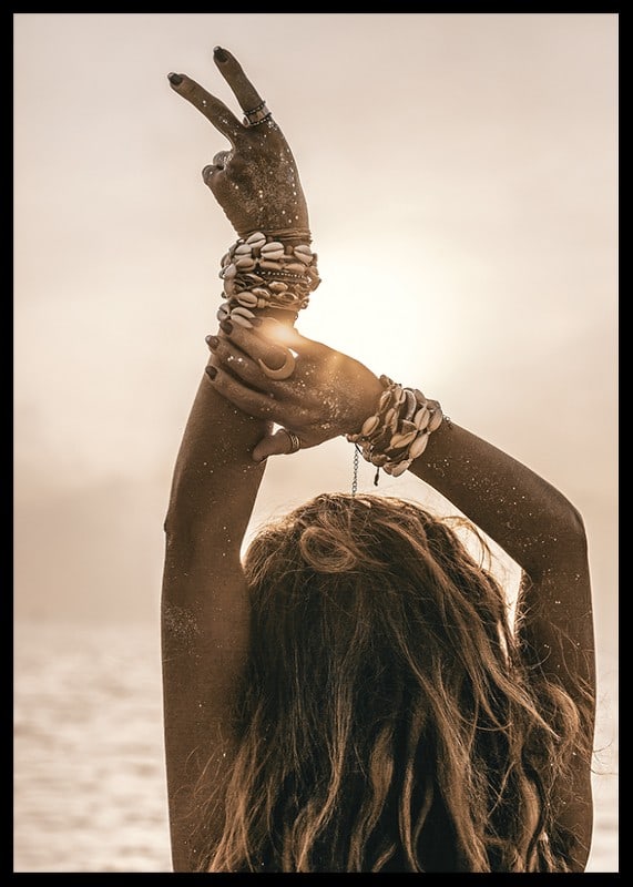 Woman with arms in the air, shell bracelet and backlight by the sea-12