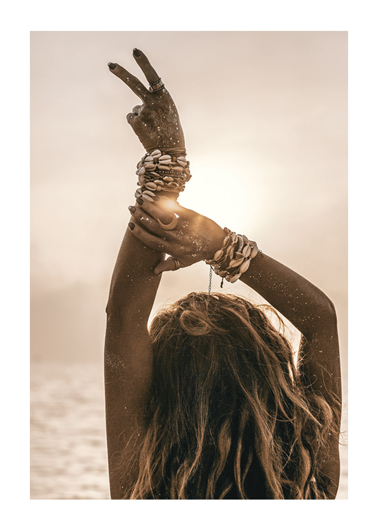 Woman with arms in the air, shell bracelet and backlight by the sea-12