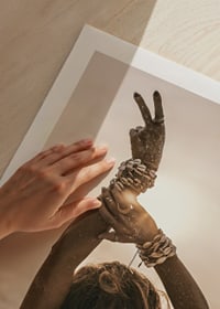 Woman with arms in the air, shell bracelet and backlight by the sea-9