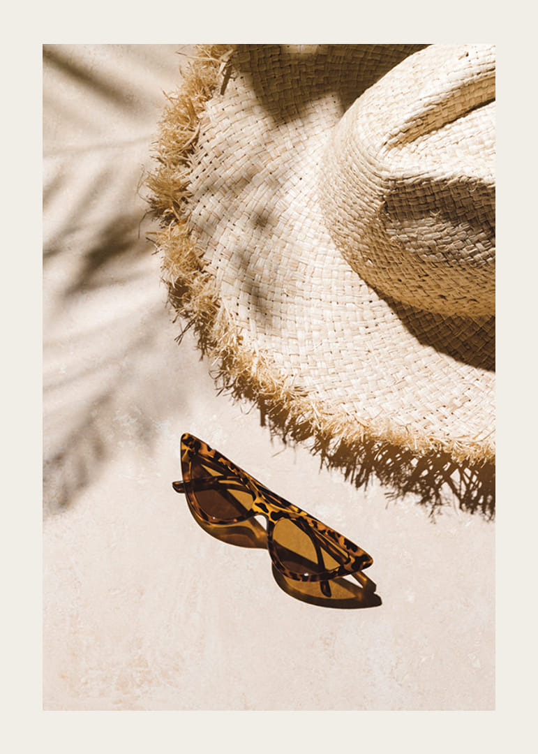 Gros plan photographique d'un chapeau de paille et de lunettes de soleil à motifs-12