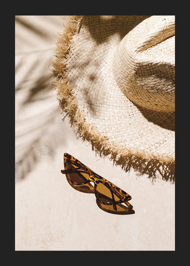 Gros plan photographique d'un chapeau de paille et de lunettes de soleil à motifs-12