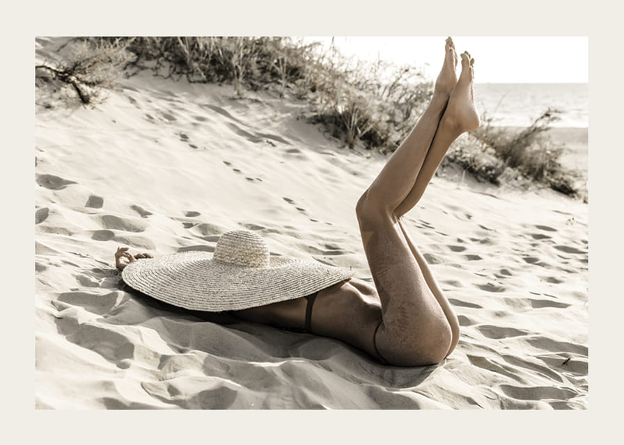 Valokuva naisesta aurinkohatussa hiekkarannalla vastavalossa-12