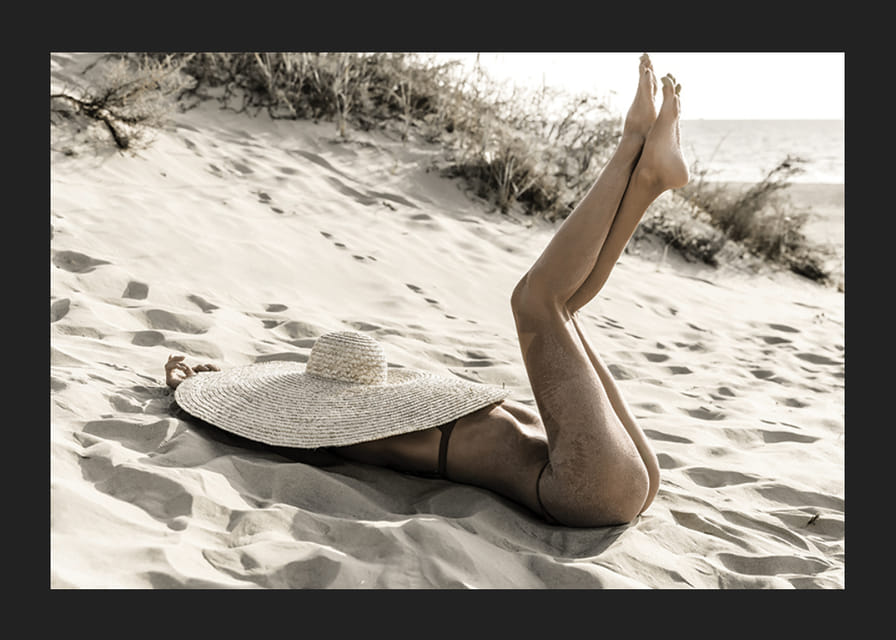 Valokuva naisesta aurinkohatussa hiekkarannalla vastavalossa-12