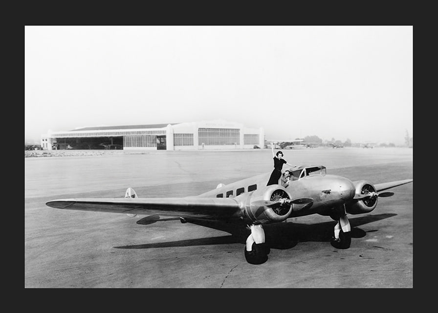 Svartvit flygplansscen med kvinna som vinkar från cockpit-12