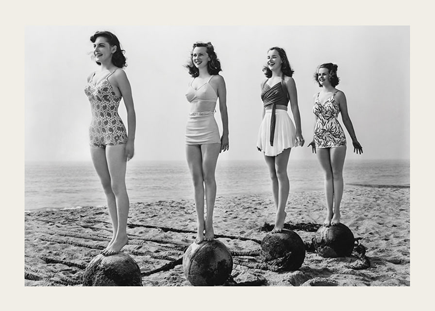 Svartvit vintagefoto av fyra kvinnor i baddräkt på strand-12