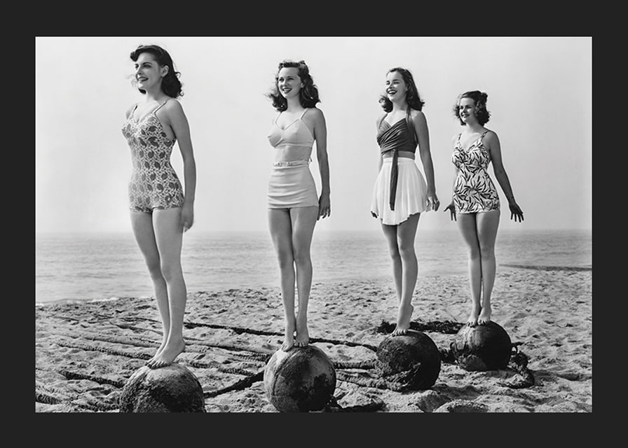 Svartvit vintagefoto av fyra kvinnor i baddräkt på strand-12