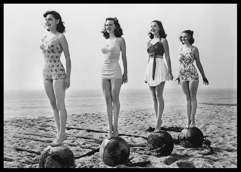 Svartvit vintagefoto av fyra kvinnor i baddräkt på strand-12
