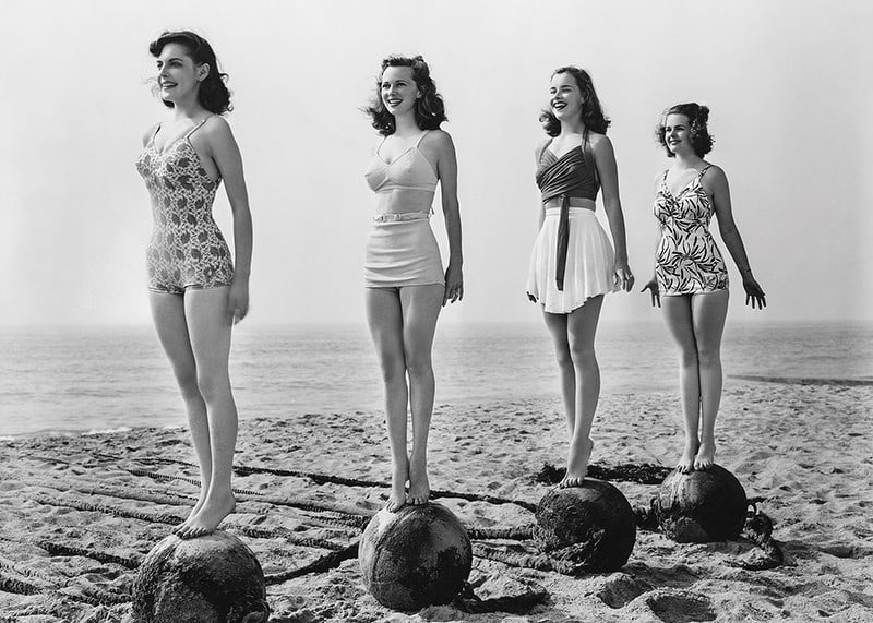 Svartvit vintagefoto av fyra kvinnor i baddräkt på strand-12