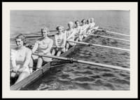 Schwarz-weiße Gruppe von Frauen rudert in einem langen Boot auf ruhigem Wasser-2