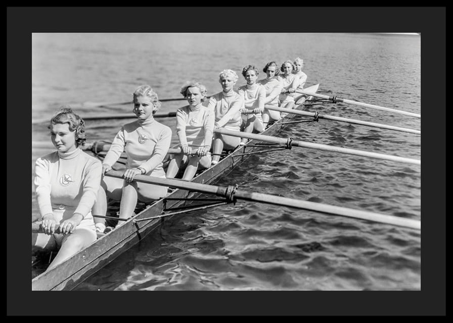 Schwarz-weiße Gruppe von Frauen rudert in einem langen Boot auf ruhigem Wasser-12