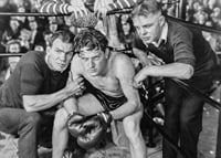 Black and white scene with boxer and two trainers in ring corner-7