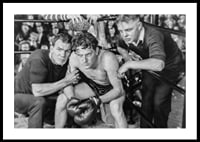 Black and white scene with boxer and two trainers in ring corner-0