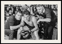 Black and white scene with boxer and two trainers in ring corner-2