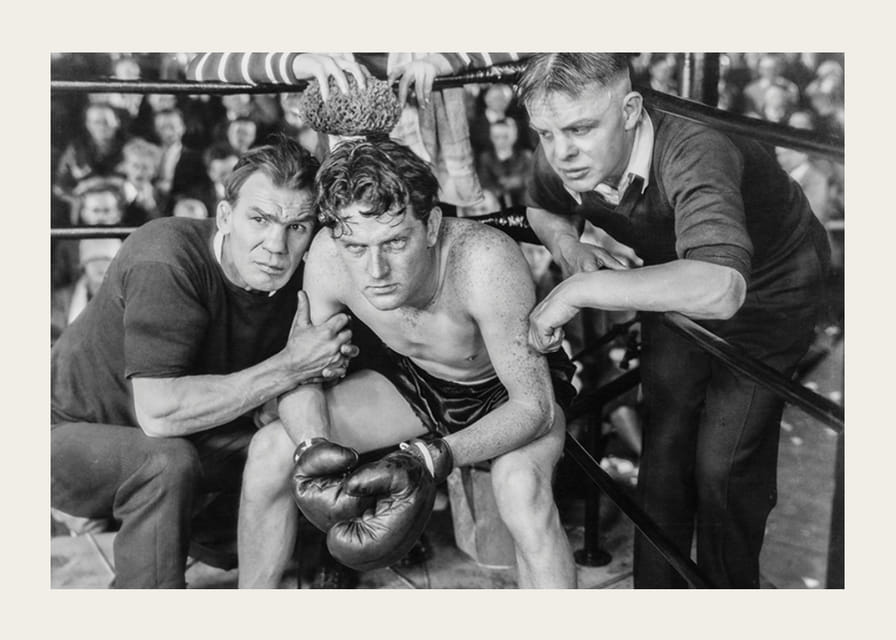 Svartvit scen med boxare och två tränare i ringhörna-12