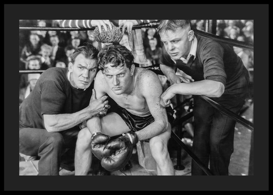 Svartvit scen med boxare och två tränare i ringhörna-12